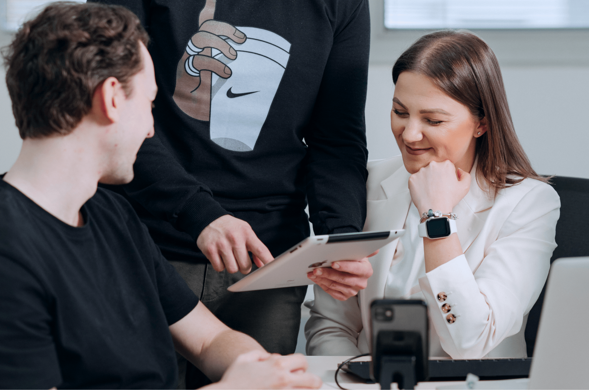 Satisfied people in an office reviewing information on an iPad